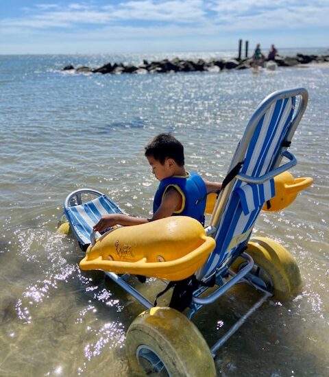boy in surf chair in ocean