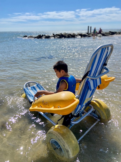 boy in surf chair in ocean