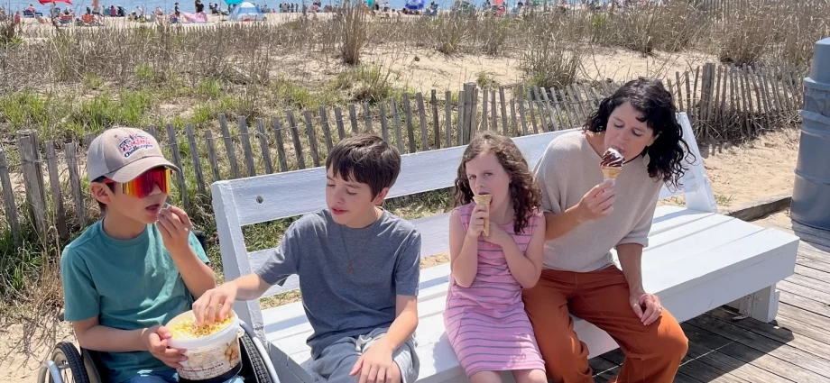 boy in wheelchair with family on bench at boardwalk