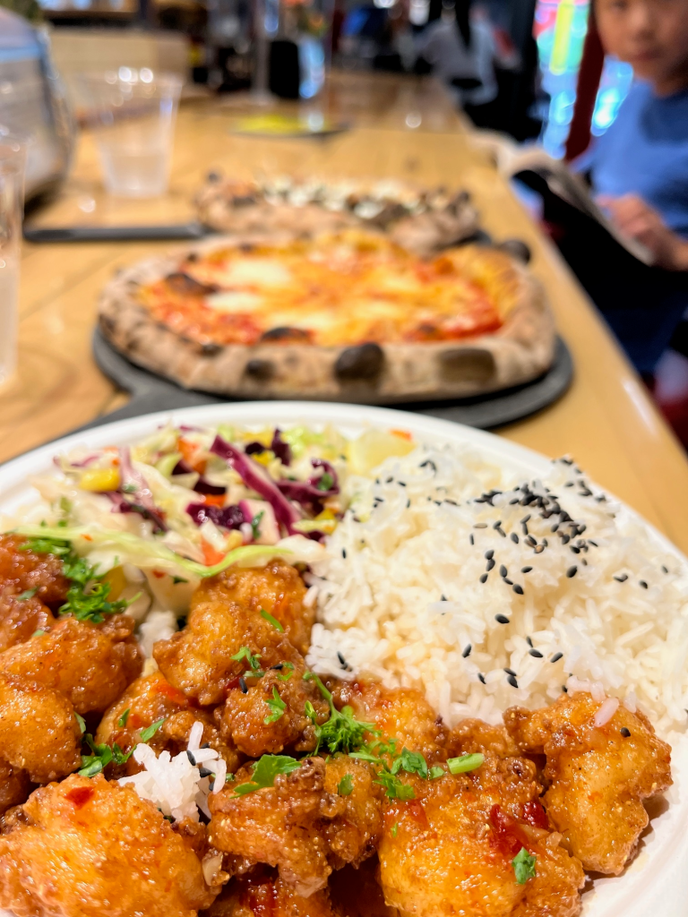 Thai shrimp dish with pizza in the background