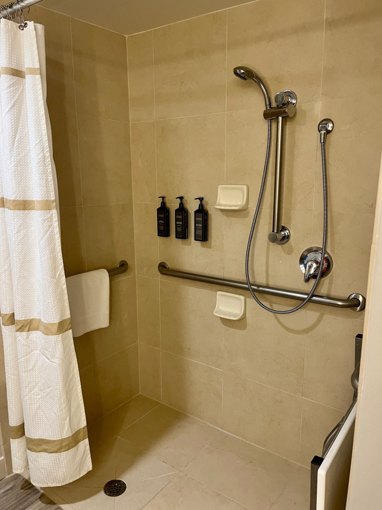 Roll in shower with bench, grab bars, and moveable handle.