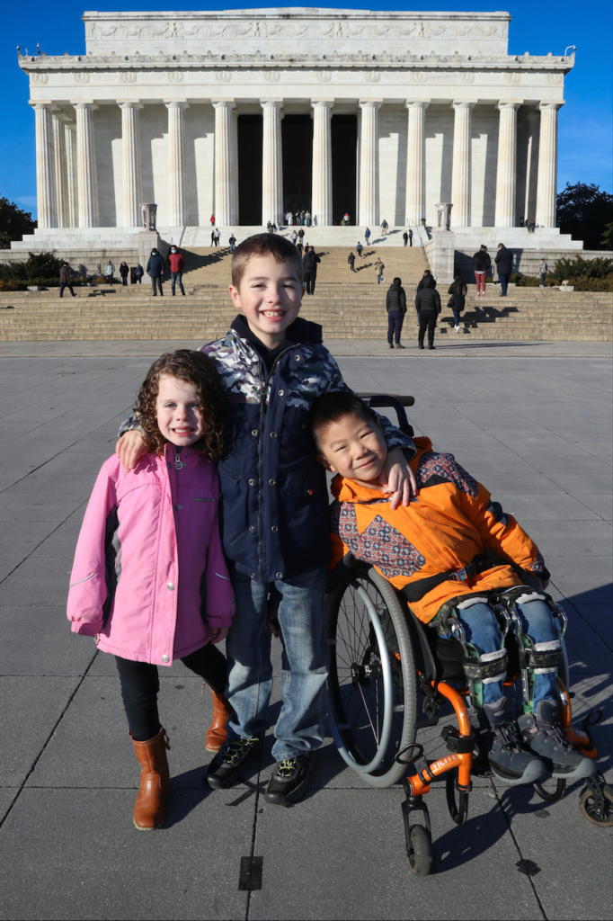 three children, one in a wheelchair, in front of lincoln memorial