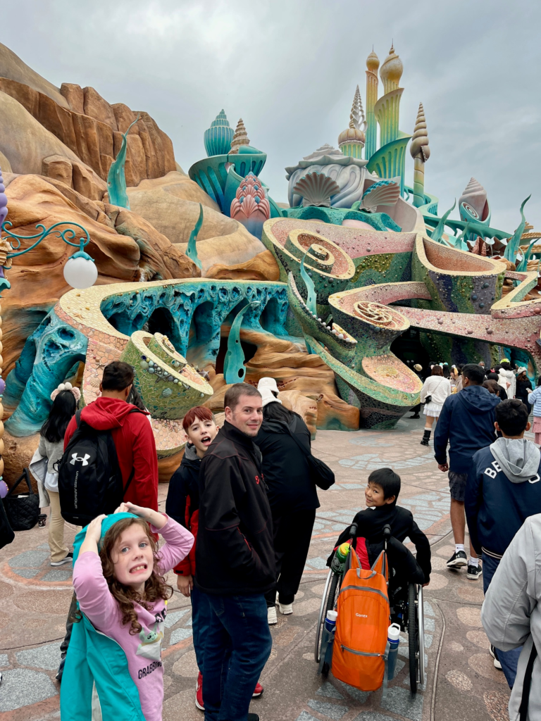 Crowds walk/roll (in a wheelchair) through sea spirals reminiscent of an underwater world.
