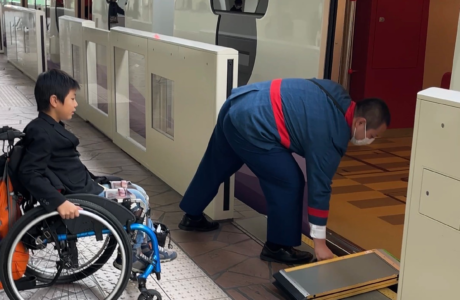 little boy in wheelchair waiting for ramp to tram