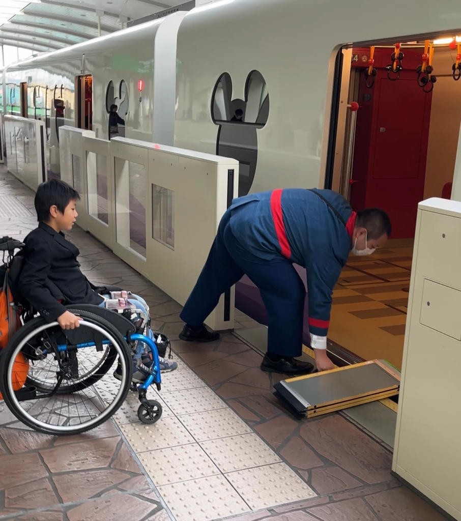 little boy in wheelchair waiting for ramp to tram