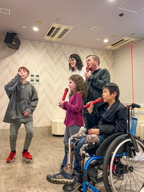 family singing into microphones looking at screen
