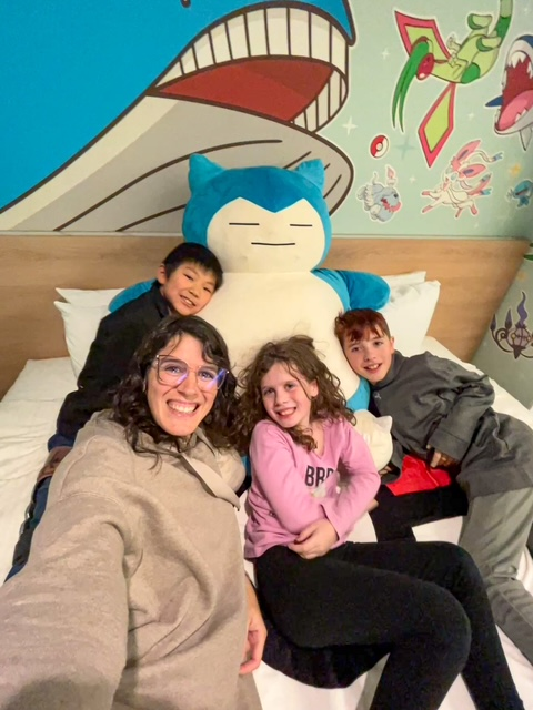 mom selfie with three kids on SNorlax in a Pokemon room
